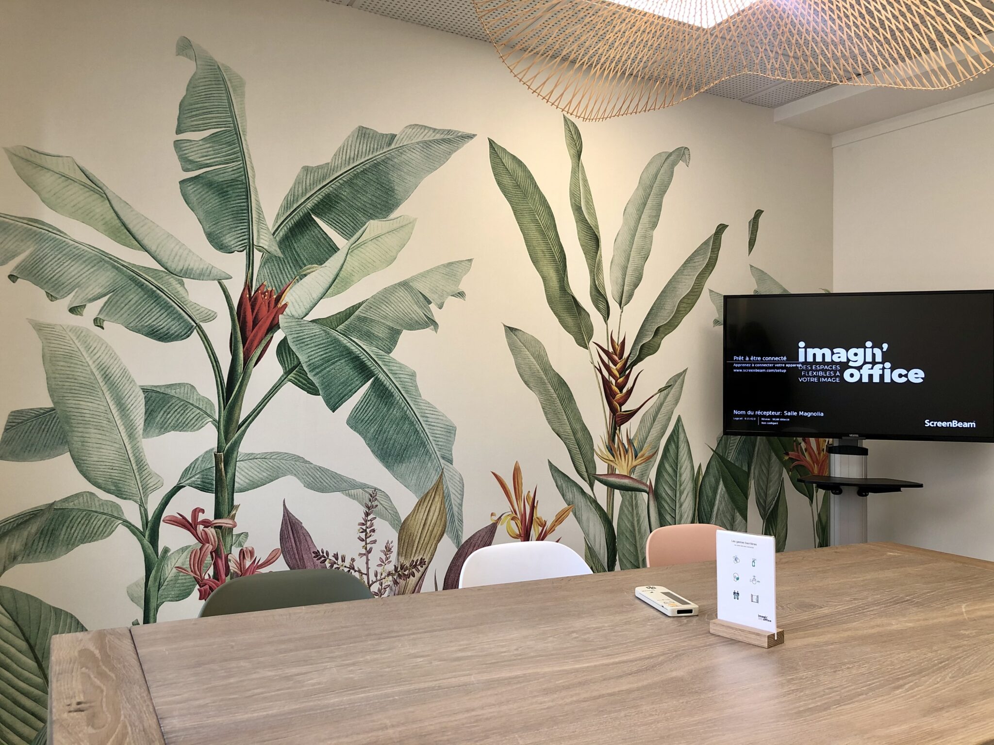 Salle de réunion avec une télé et un papier peint jungle
