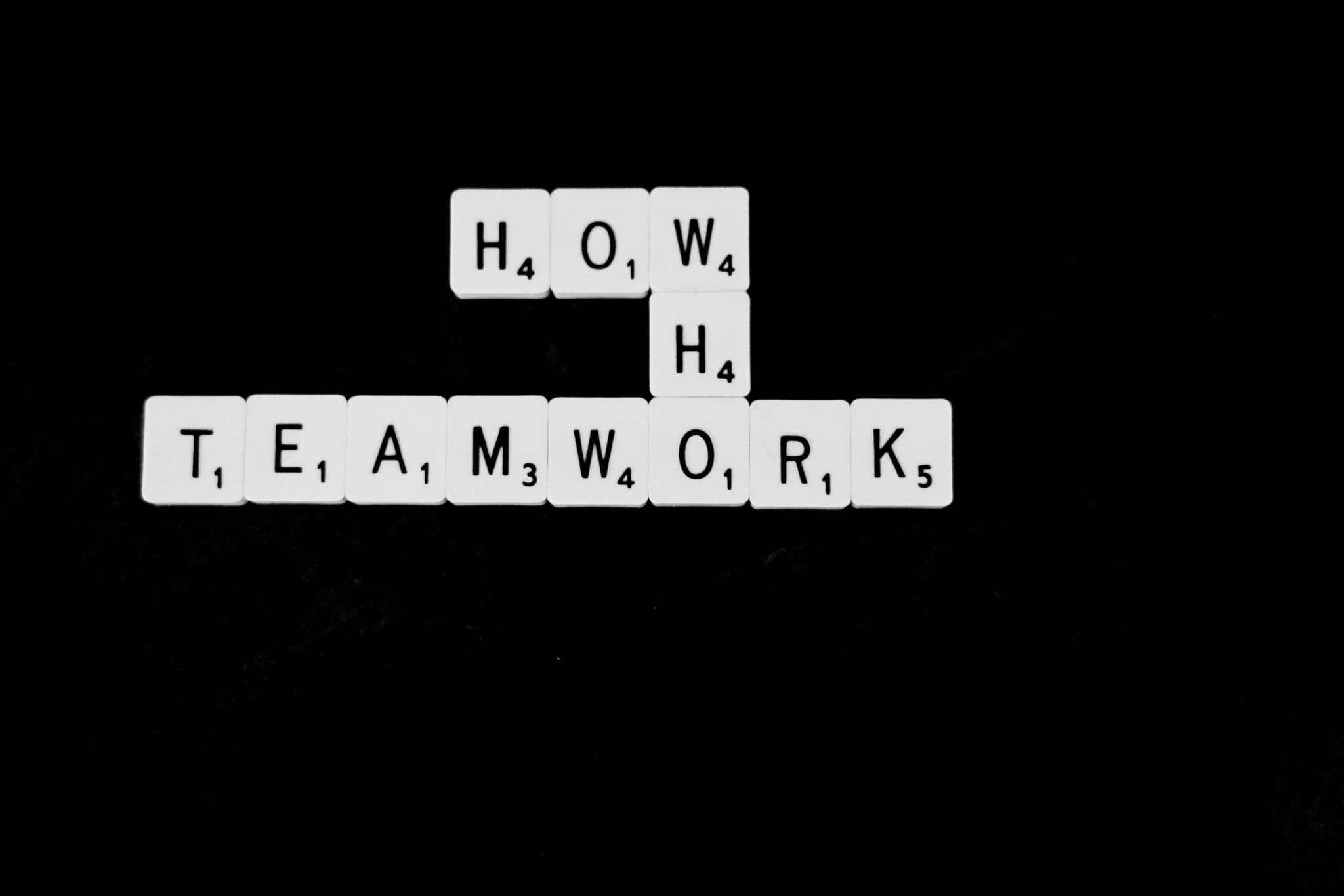 lettres de scrabble formant les mots how who et teamwork