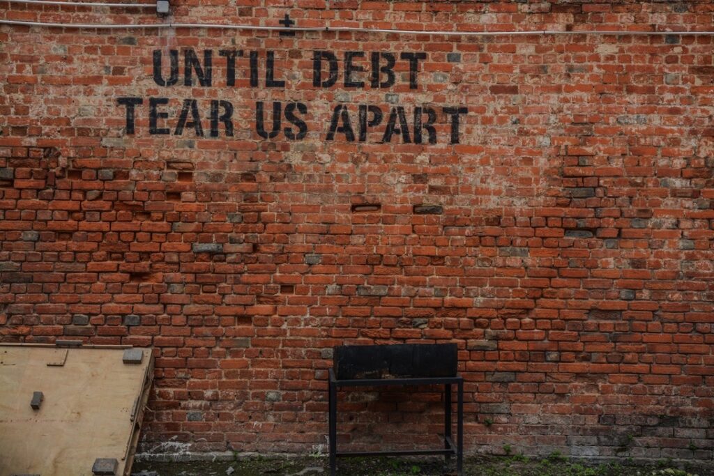 Mur avec citation "Until debt tear us apart"