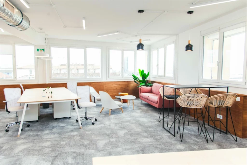 espace de coworking avec de grandes fenêtres et du mobilier de bureau